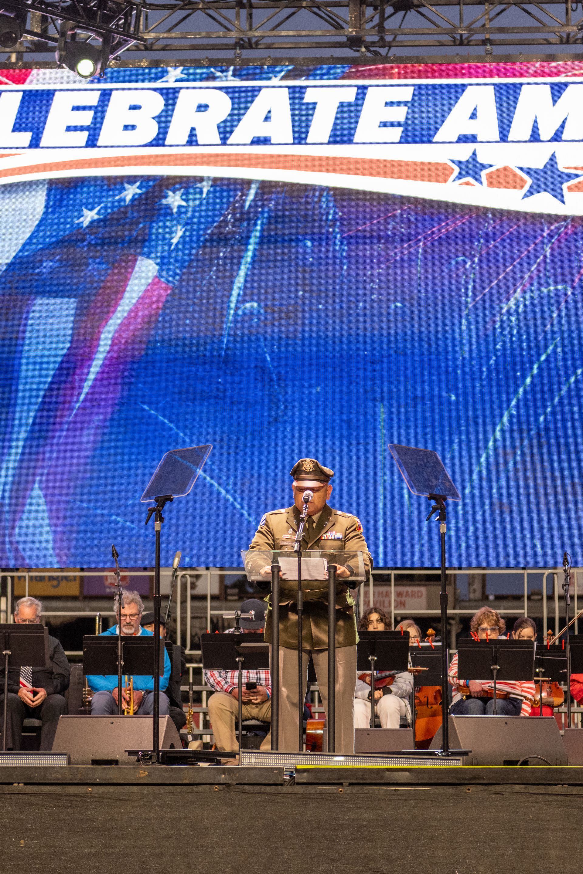 Man in uniform speaking at a concert stage with