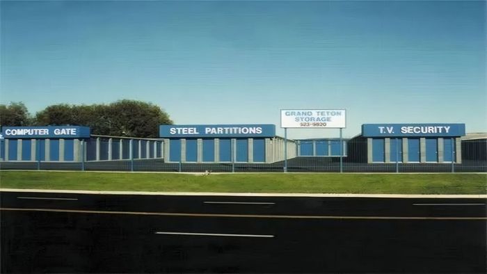 Street-side strip mall under blue sky with signs for computer sales, capital partitions, and security
