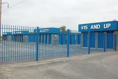 Blue fenced storefront with a sign reading “$15 AND UP”
