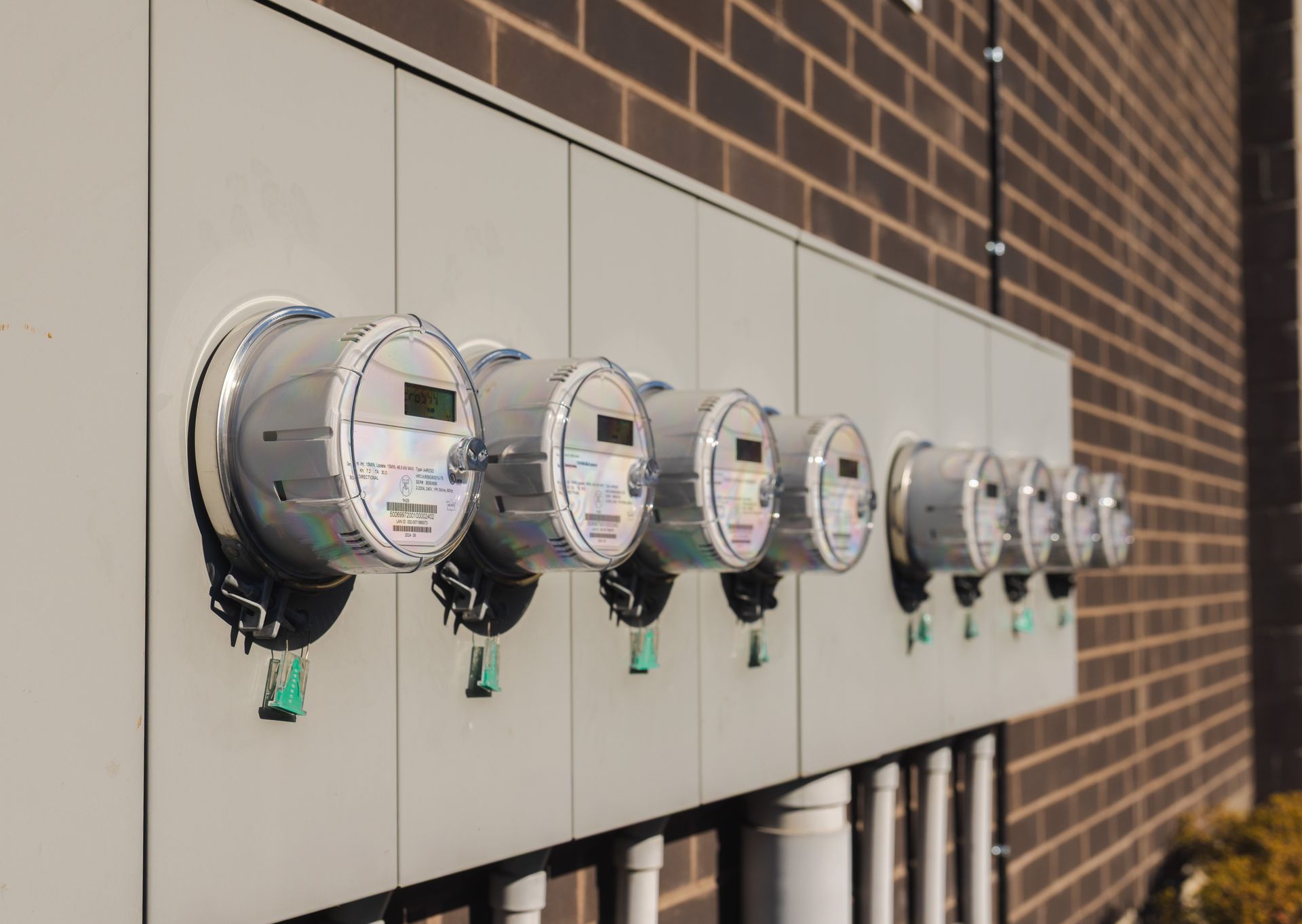 Row of electric utility meters mounted on a building exterior wall
