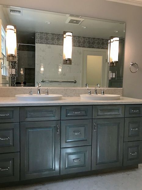 Modern bathroom vanity with double sinks, dark cabinets, mirrors, and hanging pendant lights