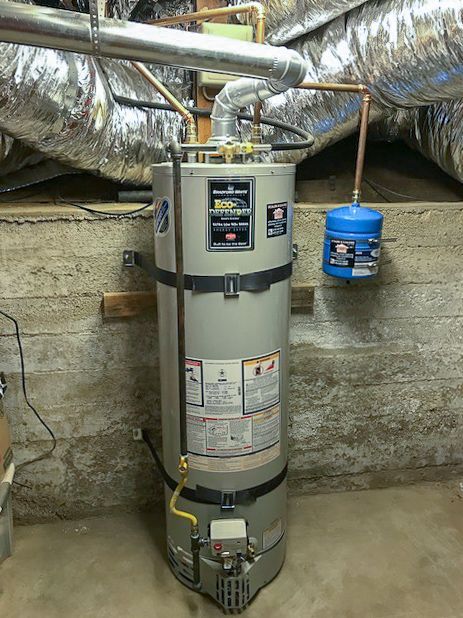 Water heater in a basement utility area with exposed ductwork and a blue expansion tank.
