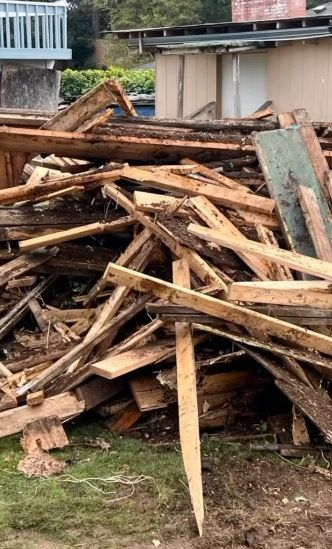 Pile of broken wooden boards in a yard.