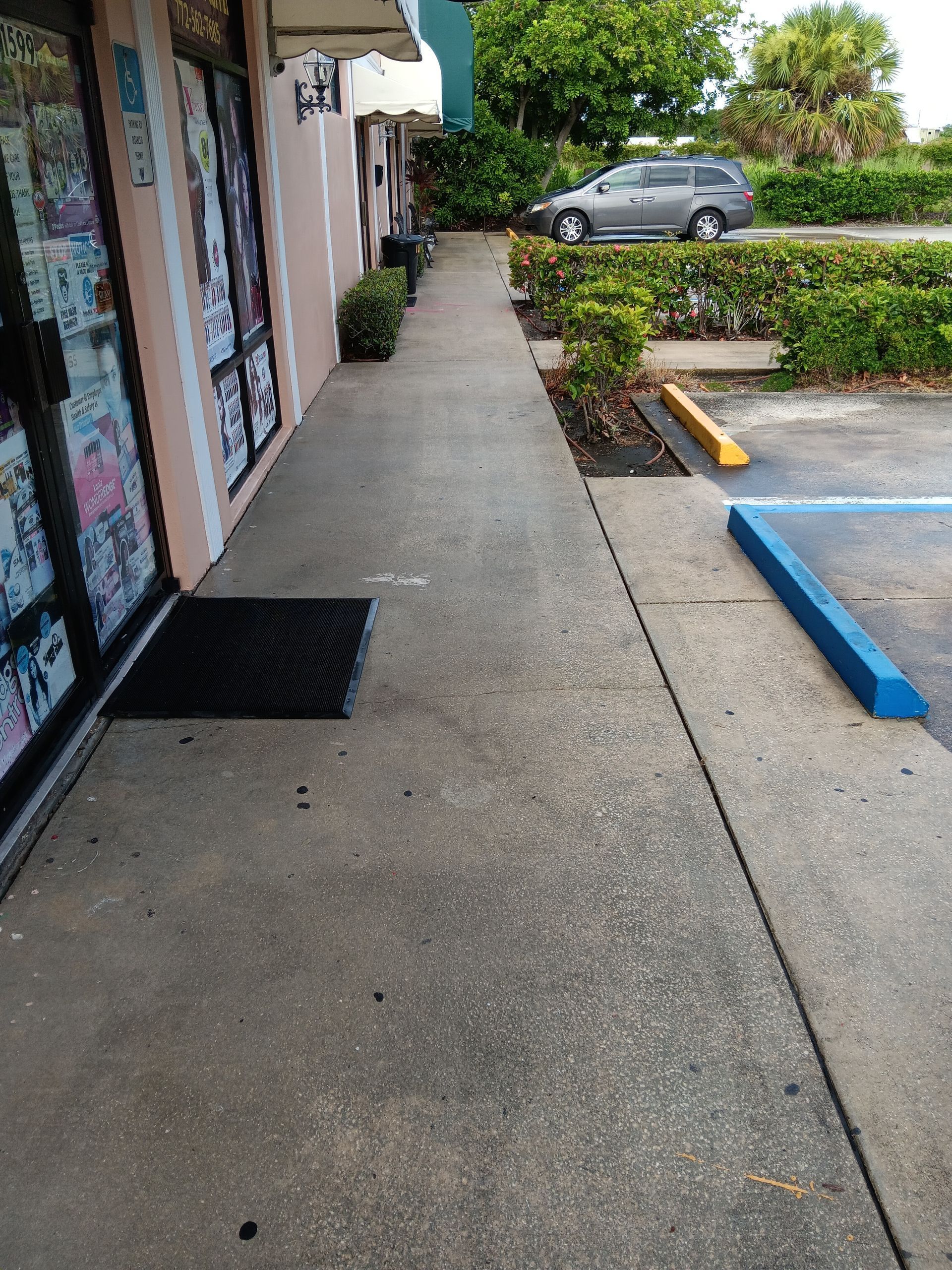 A sidewalk leading to a parking lot next to a building