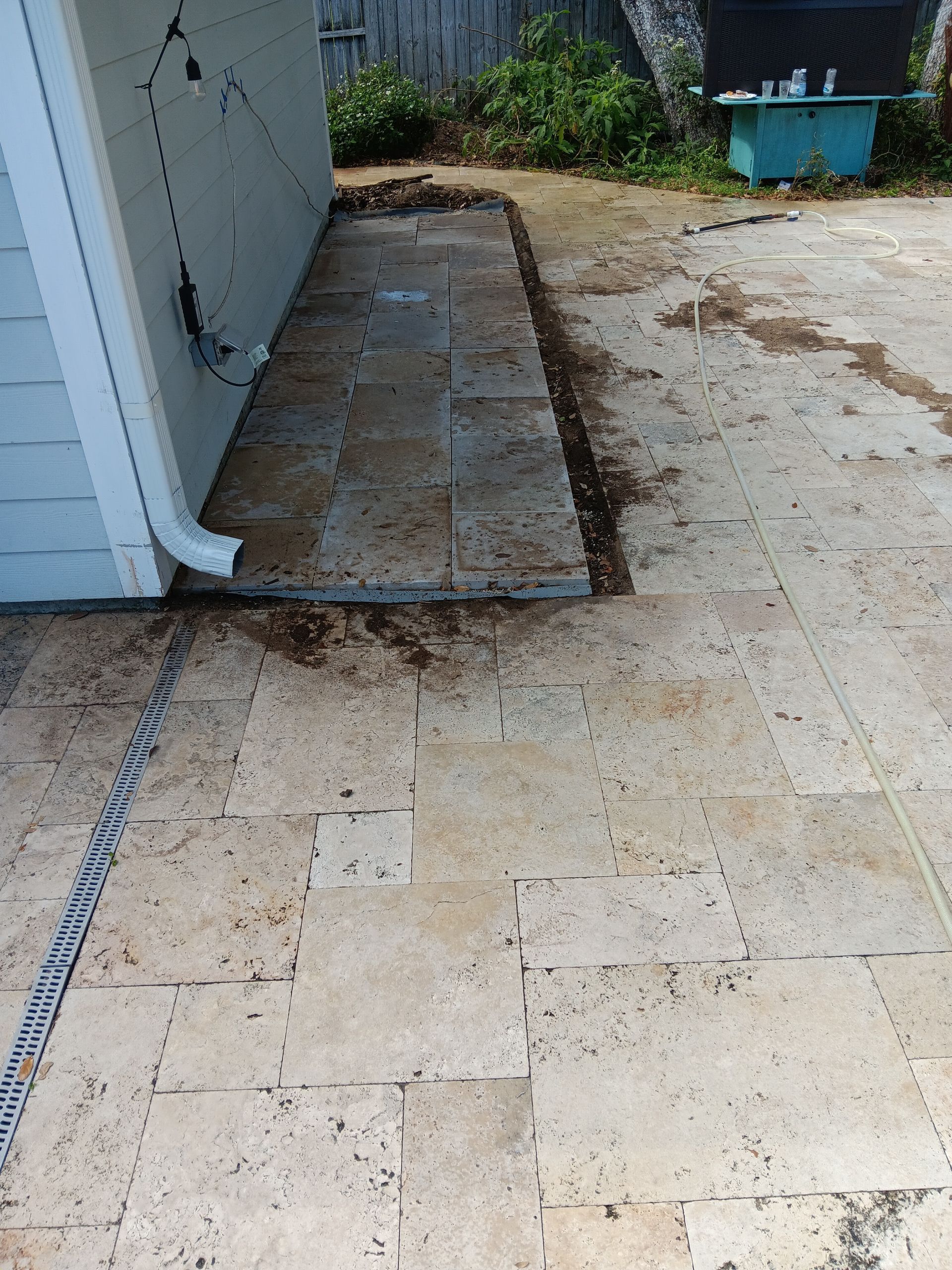 A concrete patio with a drain pipe in the middle of it
