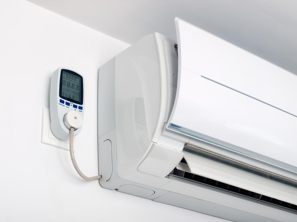 A White Air Conditioner Plugged into a Wall Outlet — Refrigerated Technologies (QLD) Pty Ltd In Airlie Beach, QLD