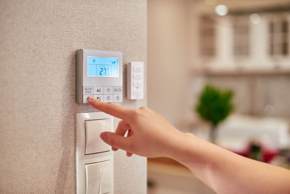 A Person Presses a Button on a Air Conditioner — Refrigerated Technologies (QLD) Pty Ltd In Airlie Beach, QLD