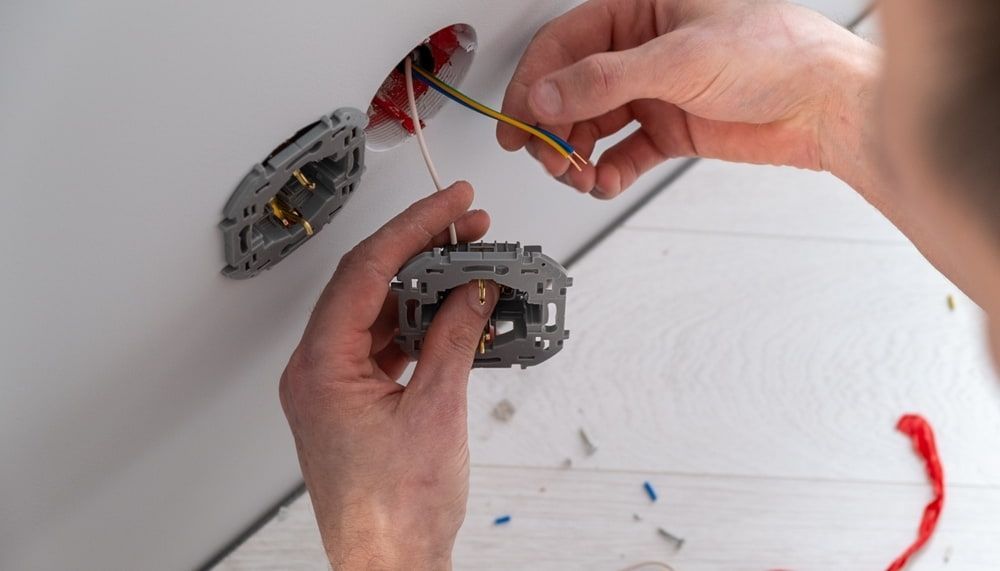 A Person is Installing a Light Switch in a Wall — Refrigerated Technologies (QLD) Pty Ltd In Proserpine, QLD