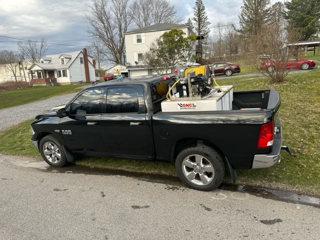 A black truck is parked on the side of the road.