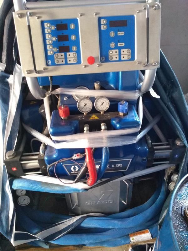 Máquina de espuma en aerosol Blue Graco con paneles de control, medidores y mangueras.
