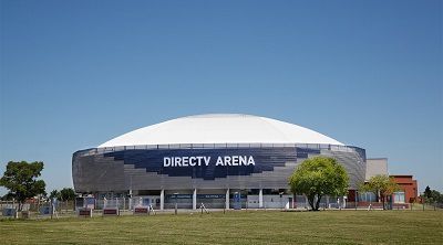 Exterior del DIRECTV Arena, un estadio moderno con techo de cúpula blanca bajo un cielo azul.
