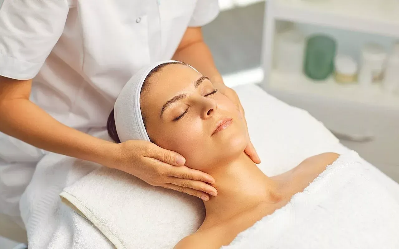 Eine Frau bekommt in einem Spa eine Gesichtsmassage.