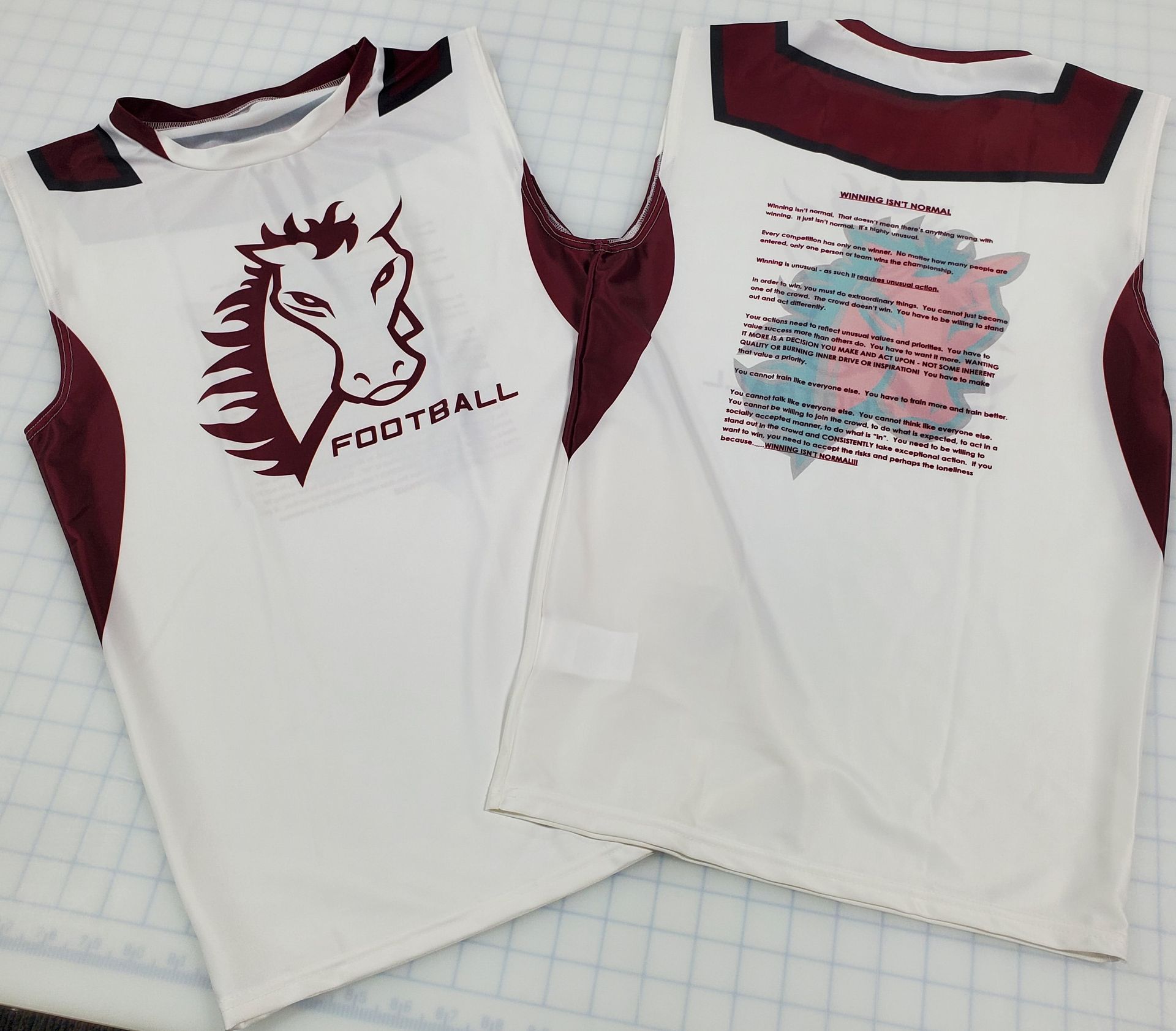 Two sleeveless white football jerseys with maroon trim; one has a horse graphic, the other a text block.
