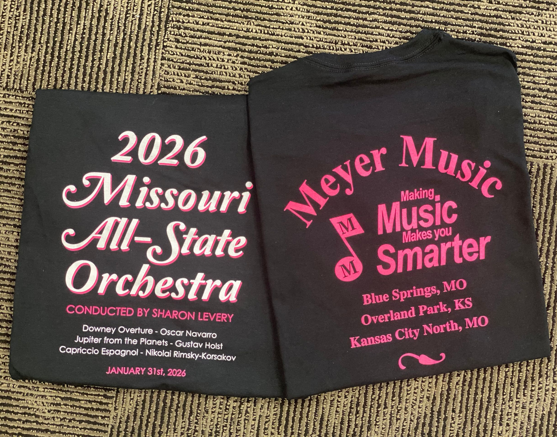 Two black t-shirts: Missouri All-State Orchestra 2026 shirt and Meyer Music shirt. Both have pink text.
