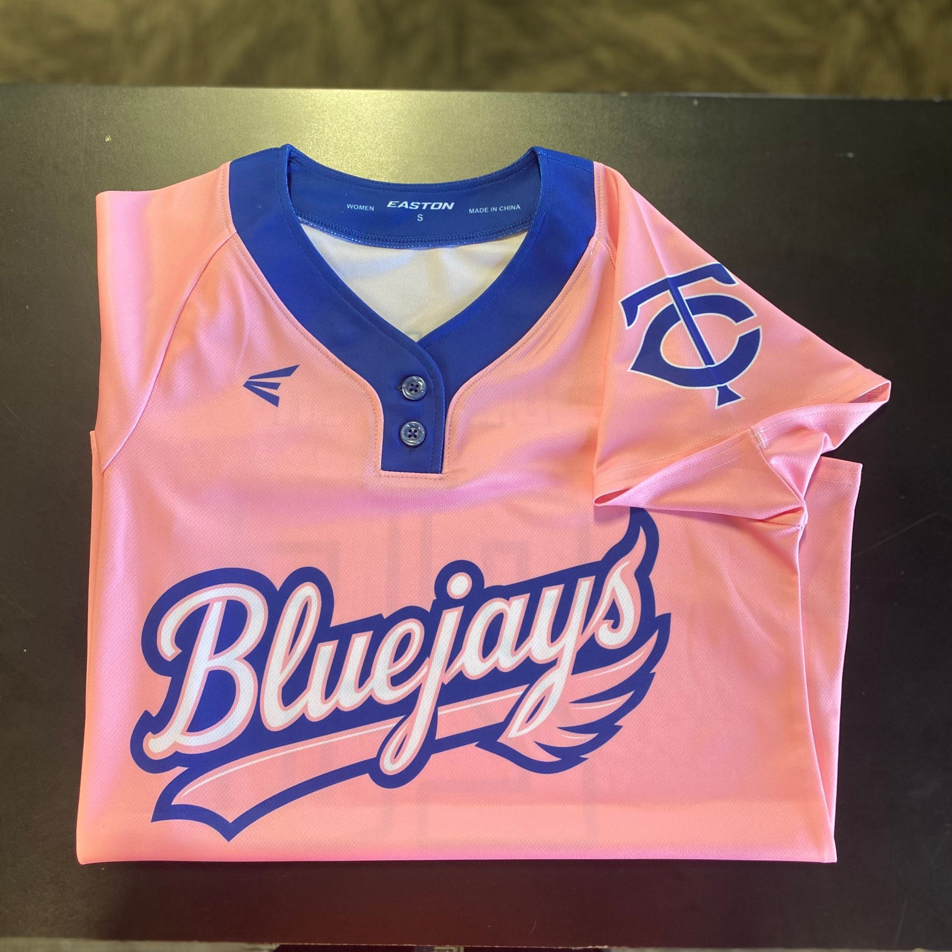 Pink Bluejays softball jersey with blue trim and logo.