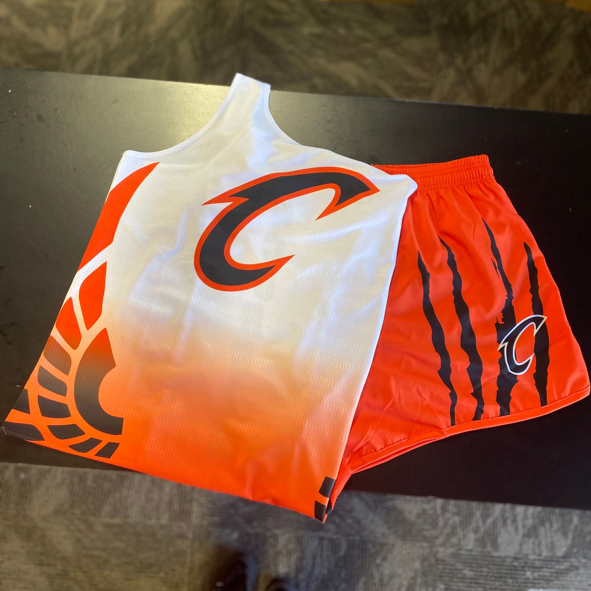 Orange and white athletic uniform. Tank top and shorts with a
