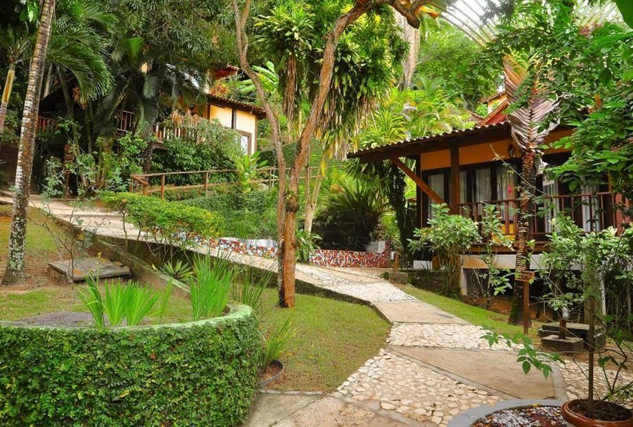 Um caminho que leva a uma casa cercada por árvores e arbustos Hotel Portaló