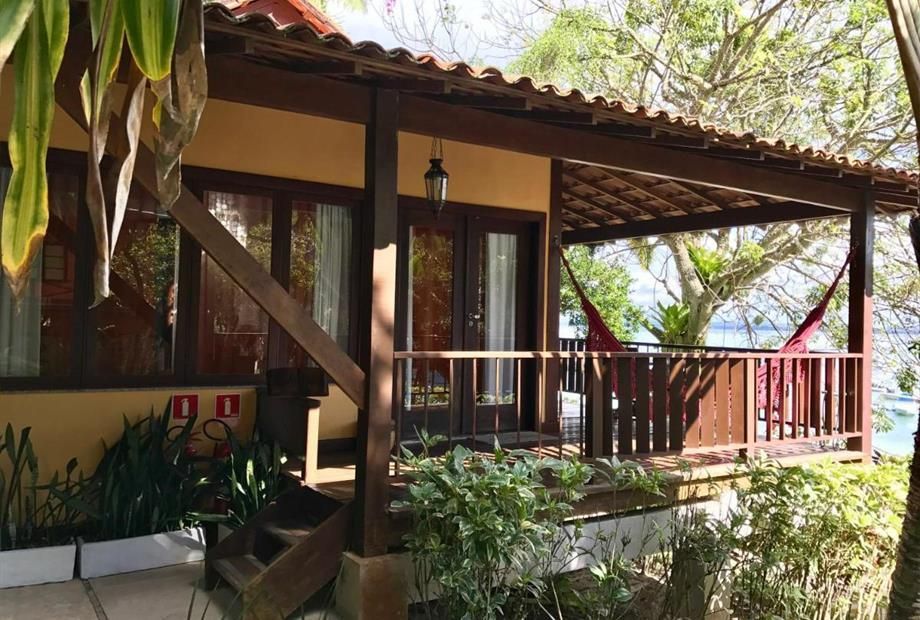 Uma pequena casa com uma rede na varanda Hotel Portaló