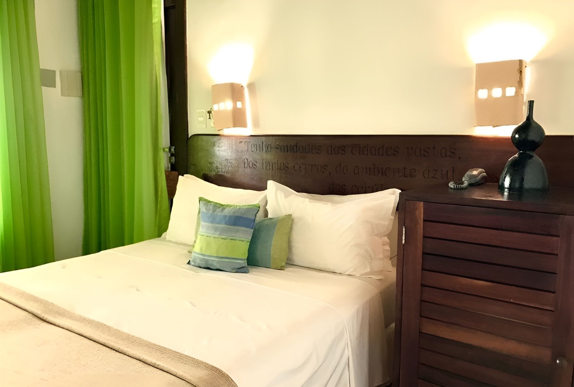 Um quarto de hotel com uma cama e cortinas verdes Hotel Portaló