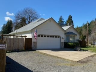 A house with a driveway and a fence - Springfield, OR - McKenzie Roofing Inc.