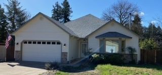 A residential property featuring a garage and a driveway - Springfield, OR - McKenzie Roofing Inc.