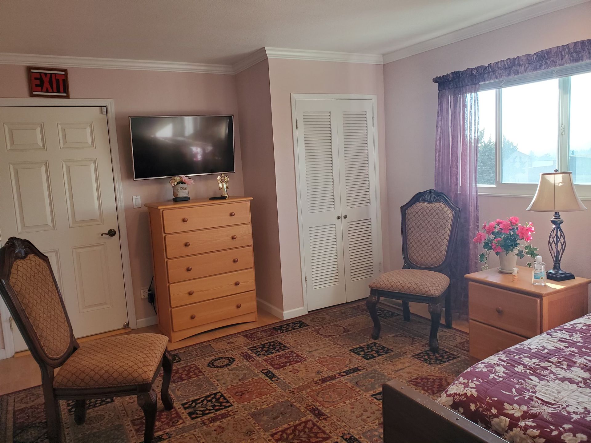 other side of the bedroom with the chairs, television and cabinets