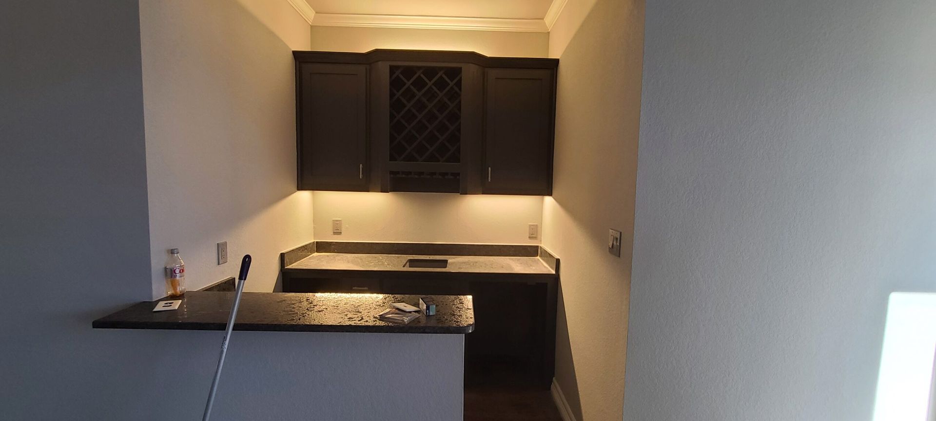 A kitchen with black cabinets and a black counter top.