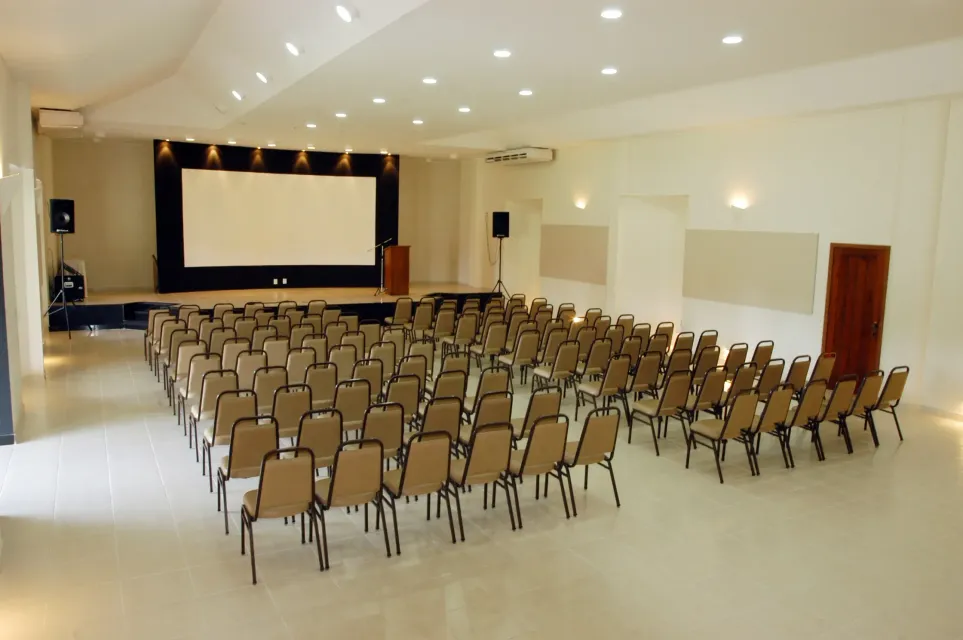 Uma sala grande com fileiras de cadeiras e uma tela grande  -HOTEL-FAZENDA-PARAISO