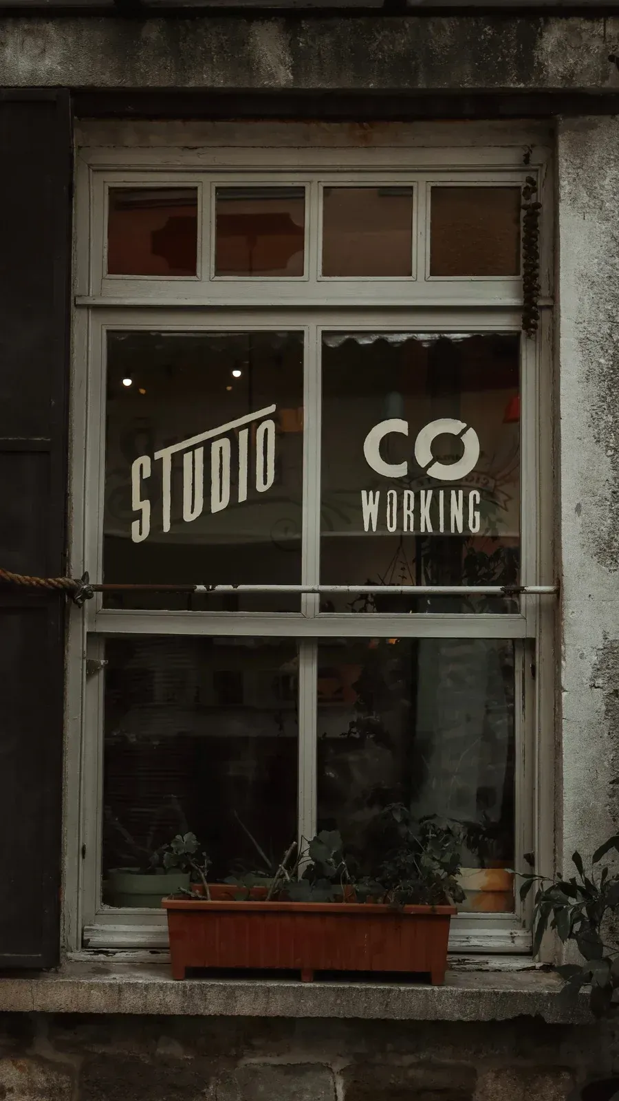 A window with a sign on it that says studio co working.