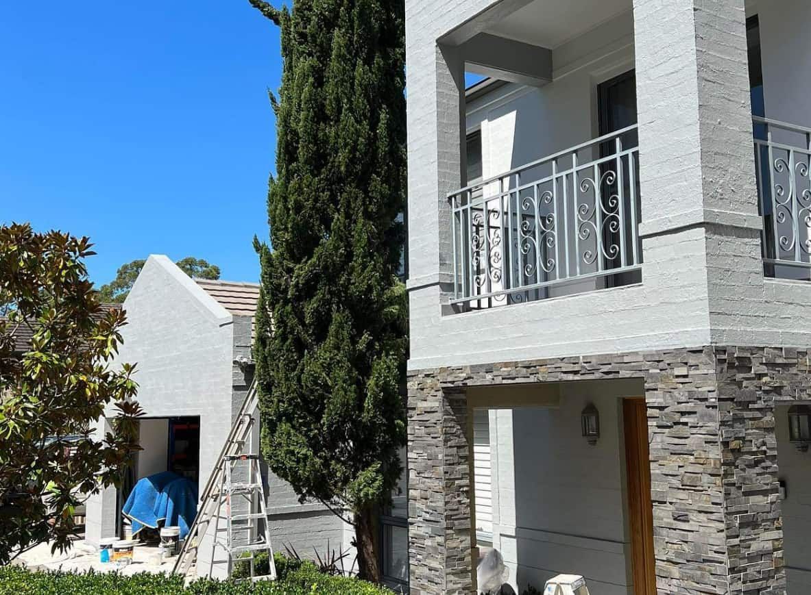 A Large White House With a Balcony is Being Painted — D & J Saverino Painting & Decorating Pty Ltd In Dapto, NSW
