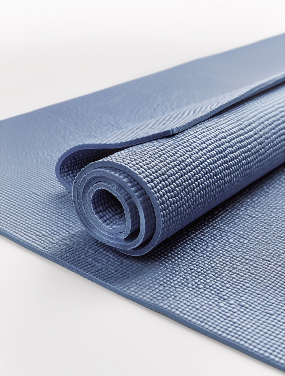 Rolled gray exercise mat with textured surface on a plain background