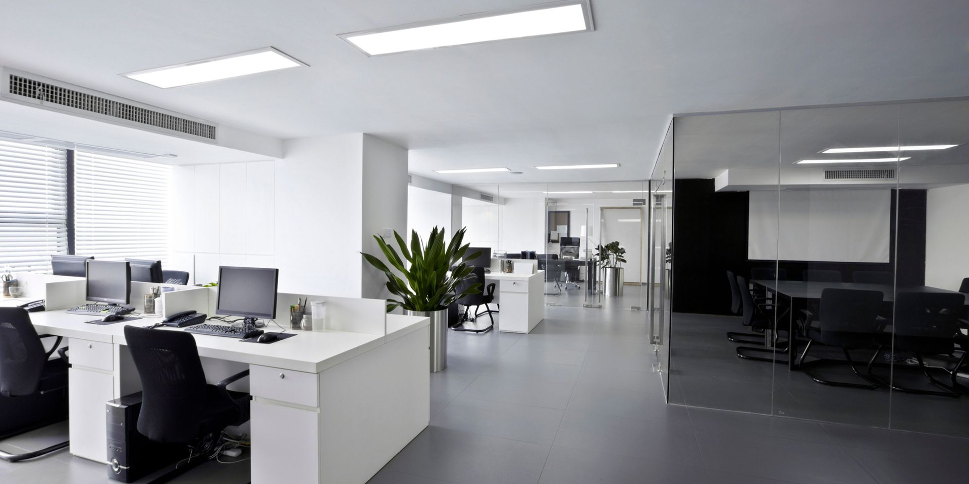 A large empty office with a lot of desks and chairs.