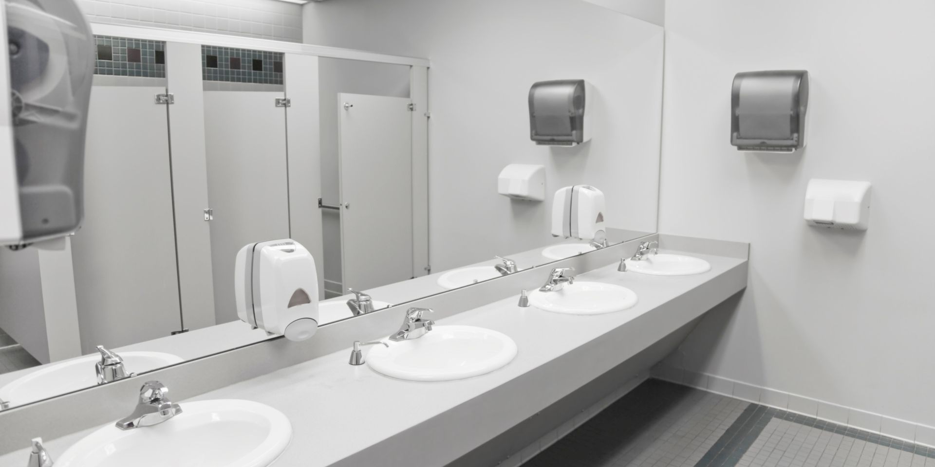 A public restroom with a row of sinks and mirrors.