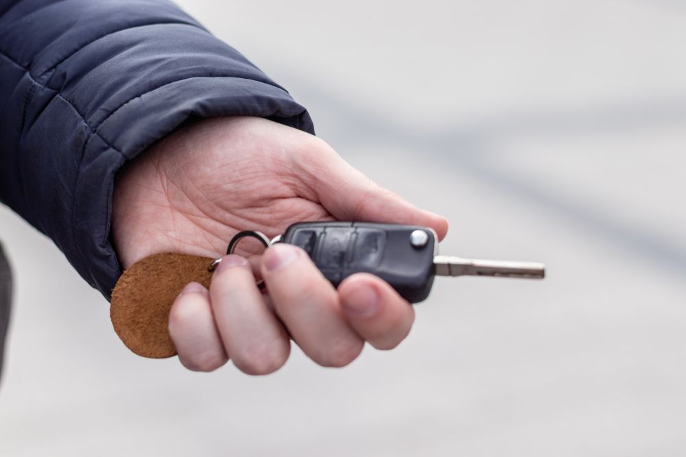 A Person is Holding a Car Key in Their Hand — Duffys Car Rentals in Atherton, QLD