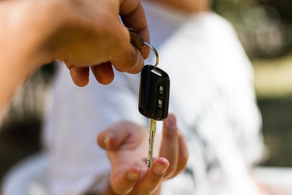 A Person is Handing a Car Key to Another Person — Duffys Car Rentals in Atherton, QLD