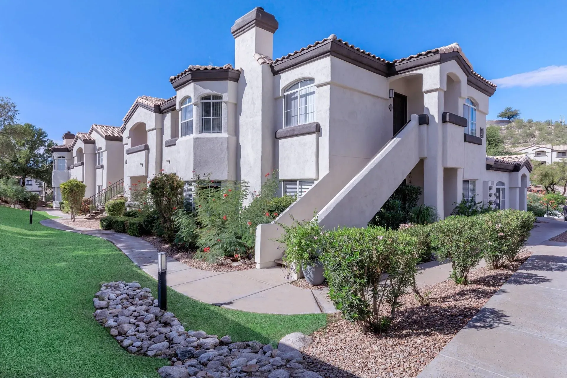 Exterior view of apartment buildings with stairs and landscaping at Pinnacle Heights in Tucson, AZ.