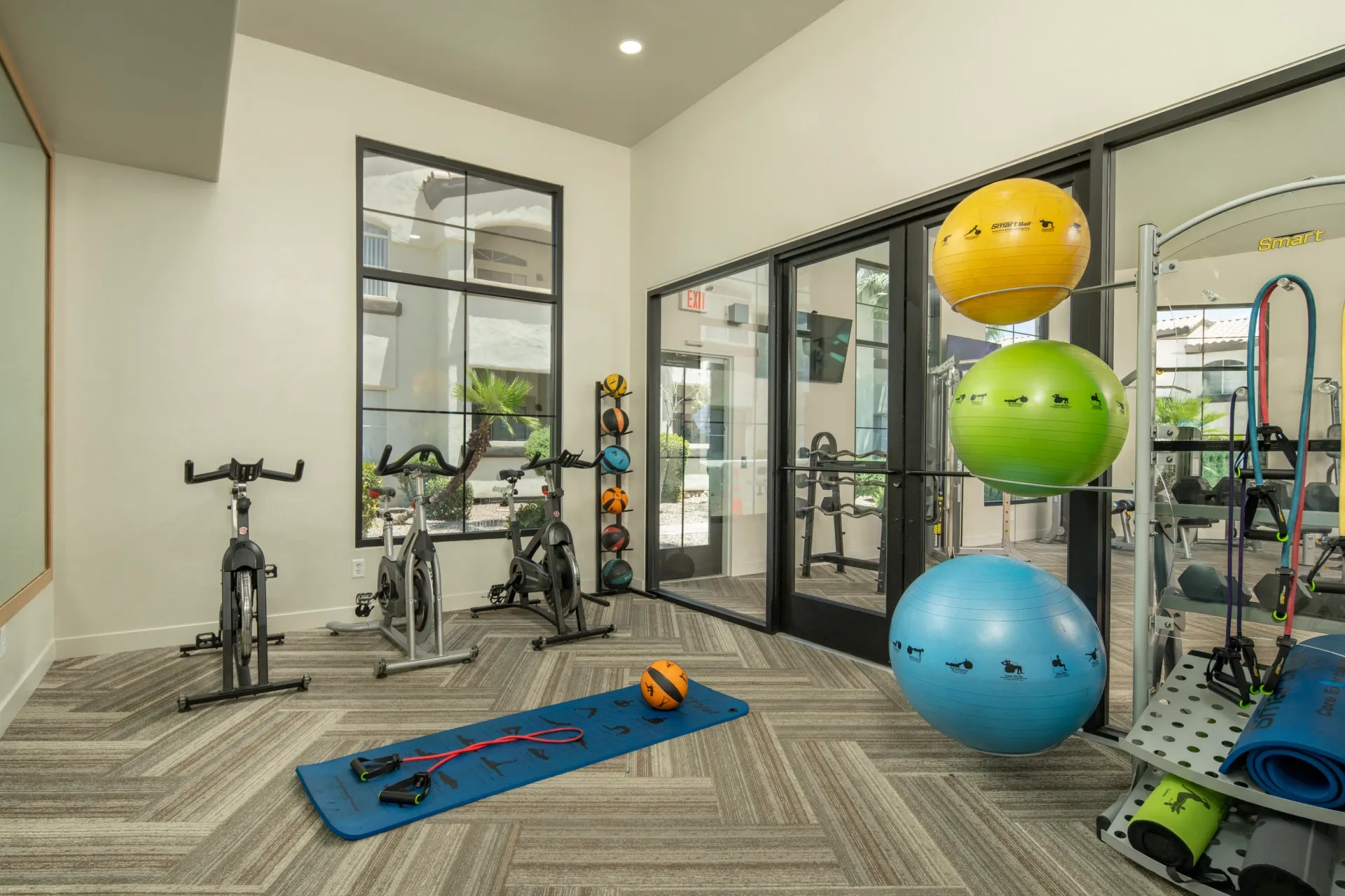 Interior of a modern fitness center with cardio equipment and exercise balls at Pinnacle Heights in Tucson, AZ.