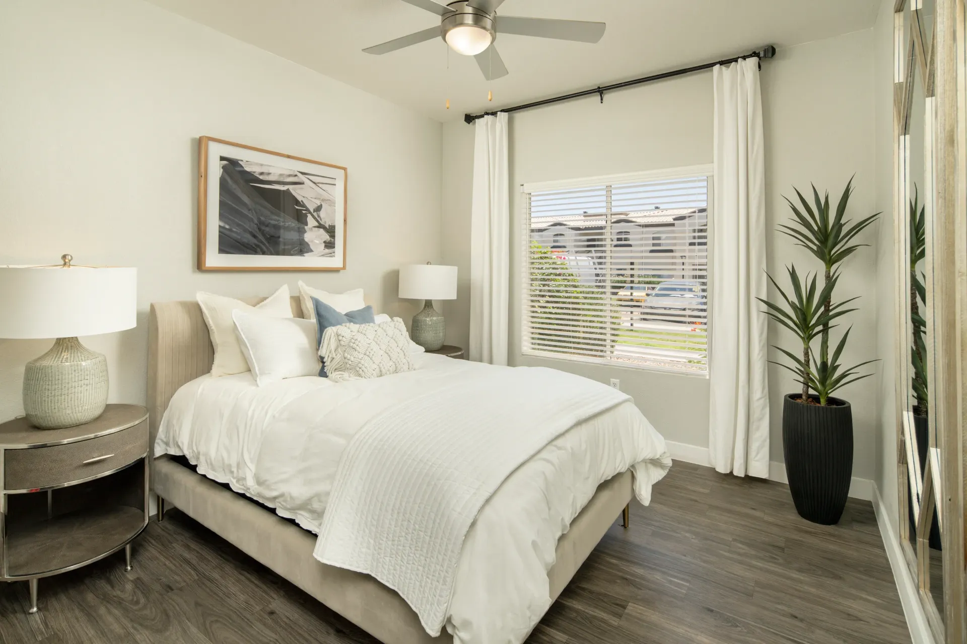 Bedroom with a queen-size bed, nightstand, and ceiling fan at Pinnacle Heights in Tucson, AZ.