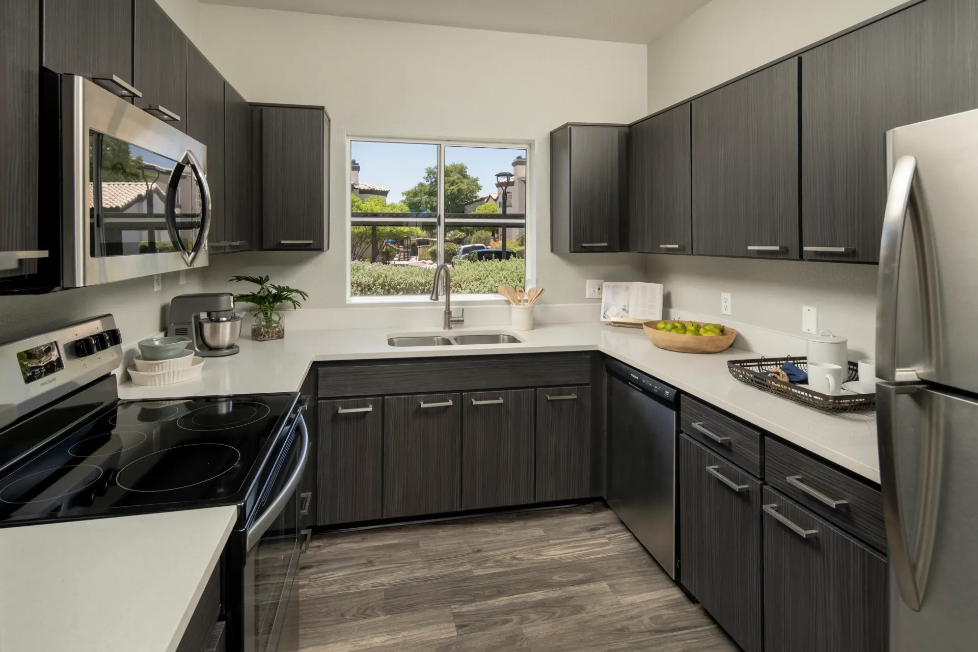 Modern kitchen with dark cabinetry, stainless steel appliances, and a large sink at Pinnacle Heights in Tucson, AZ.
