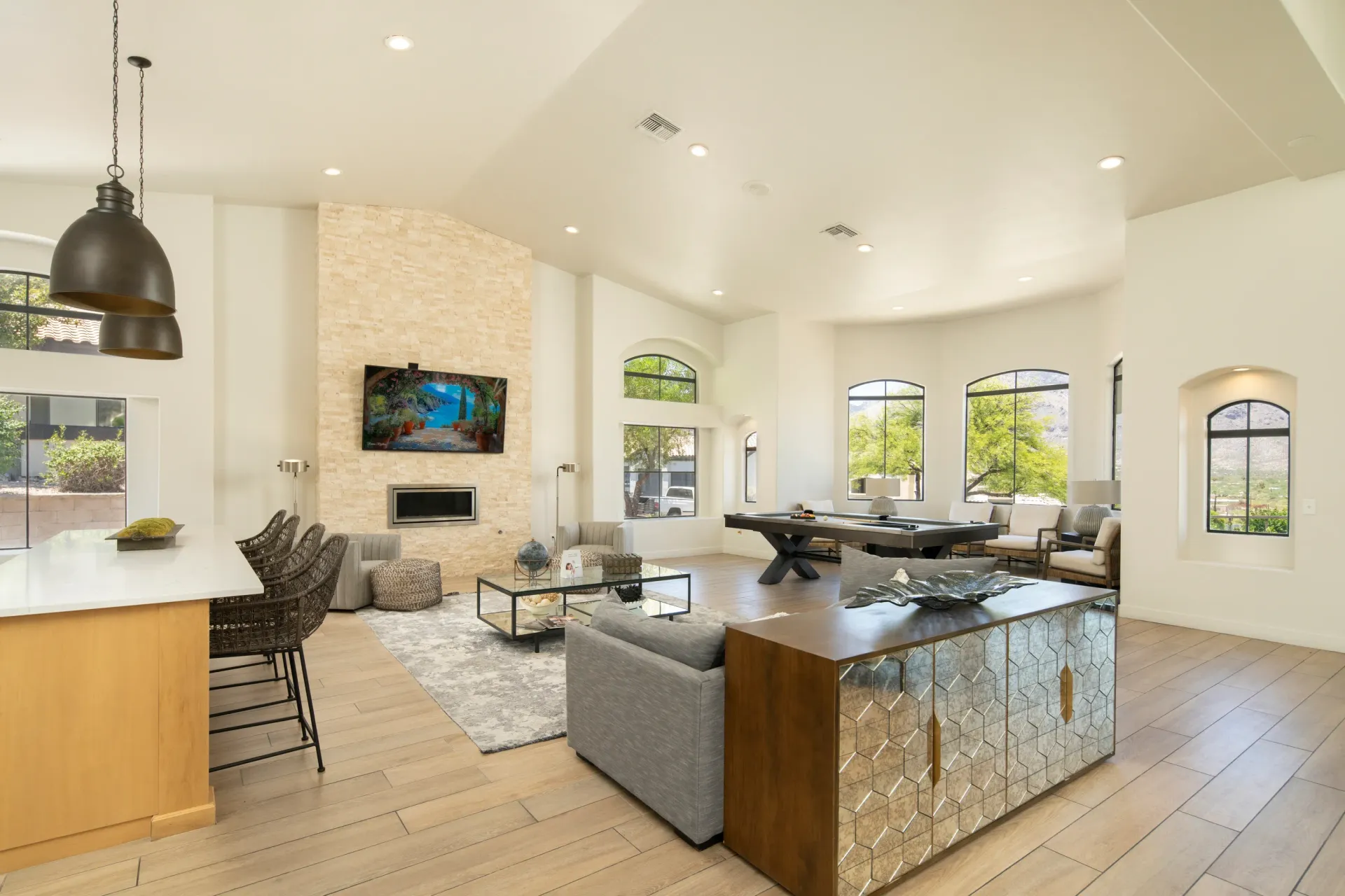 Spacious community lounge with a pool table, fireplace, and seating areas.