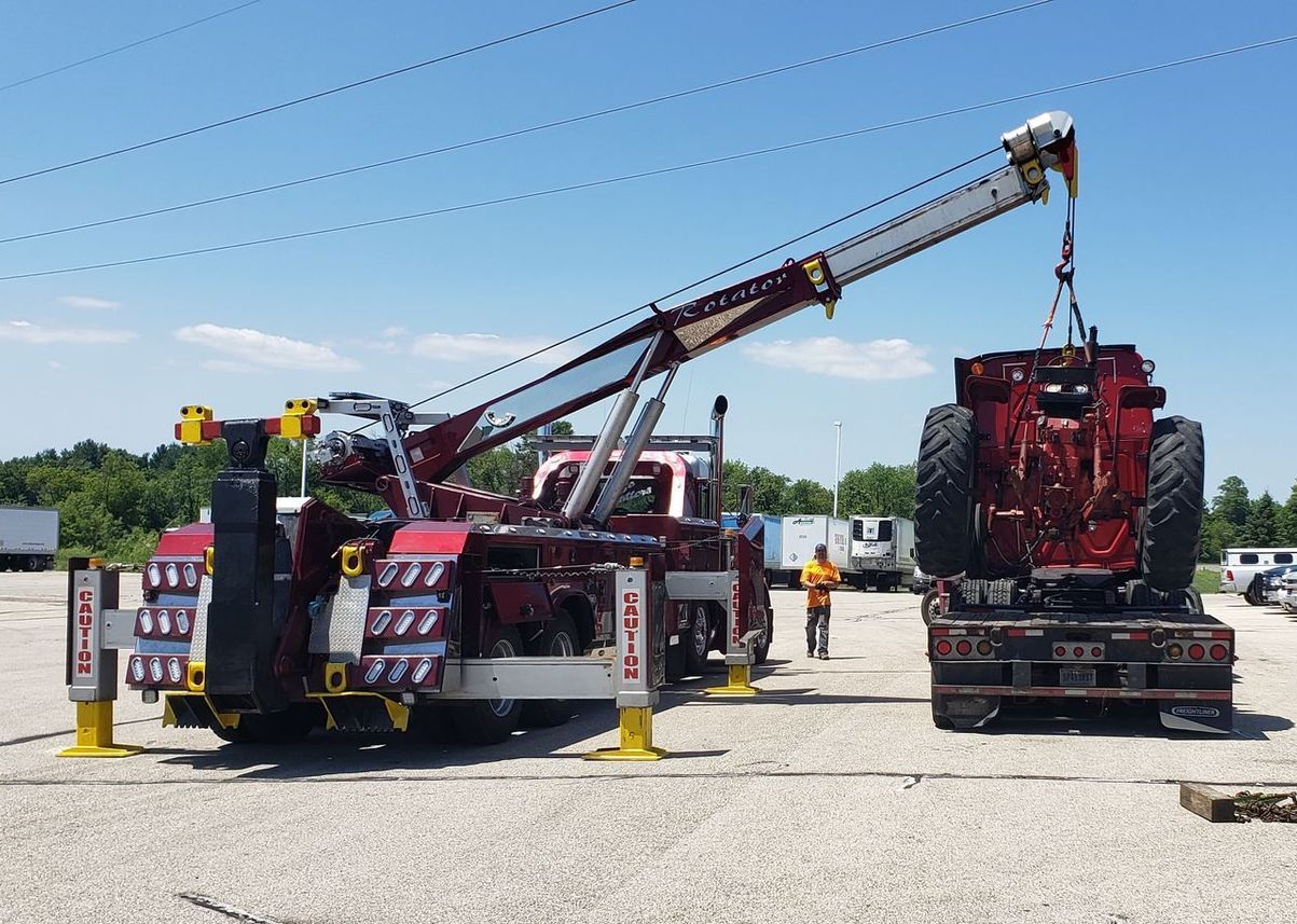 A red tow truck with a crane attached to it