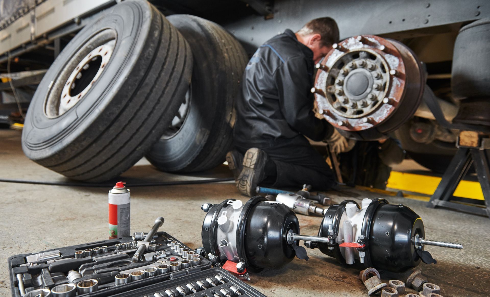 A man is working on a truck in a garage.