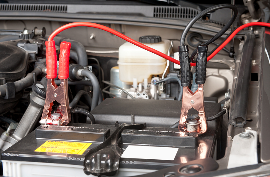 A car battery is being charged with red and black wires.