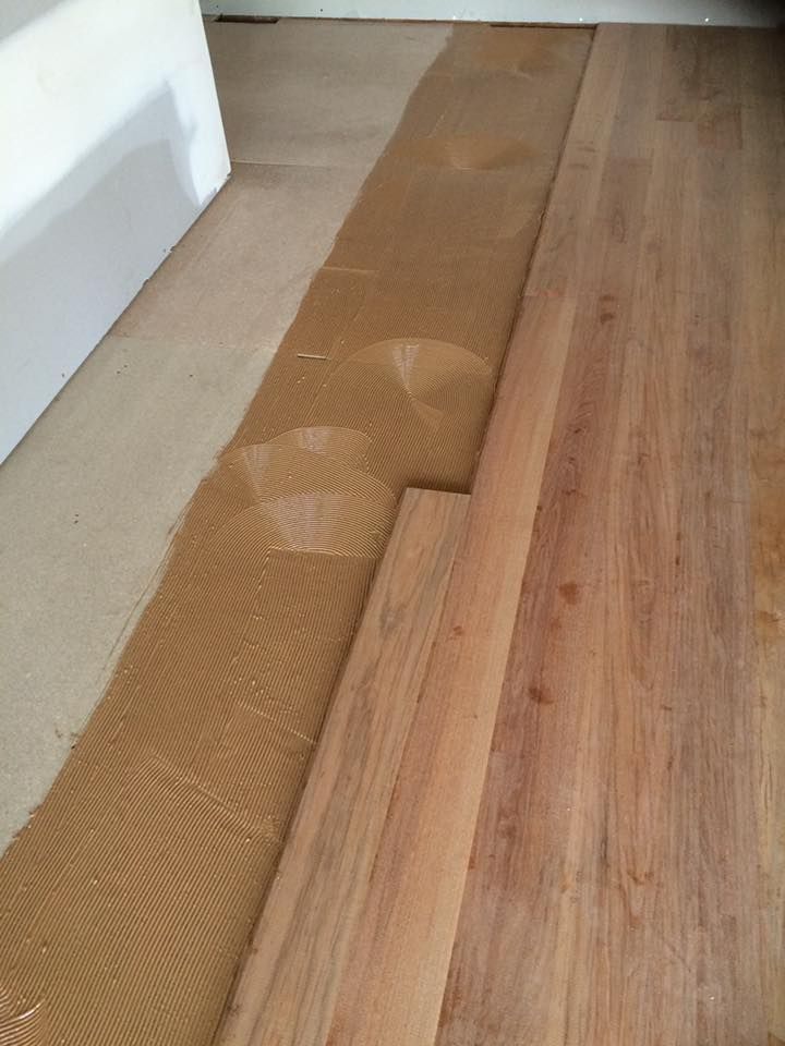 A wooden floor is being installed in a room.