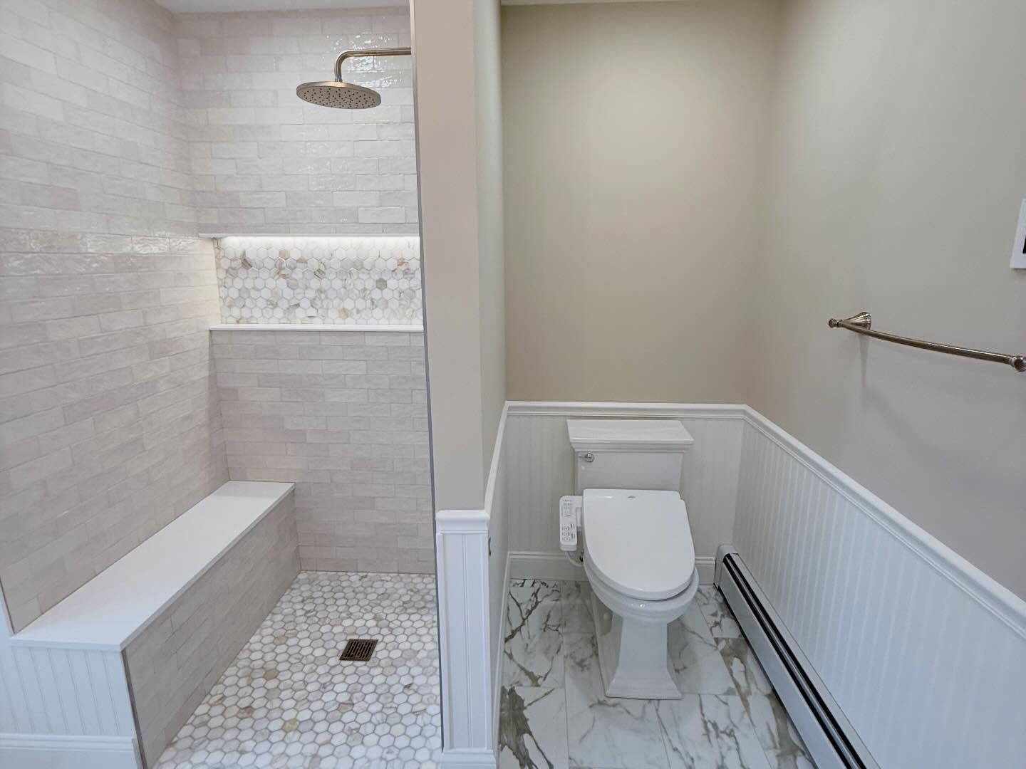 Accessible bathroom with walk-in shower, toilet, and gray tile walls and floor.