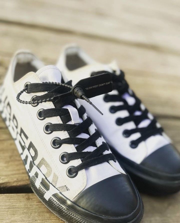 A pair of white and black sneakers with the word converse on them