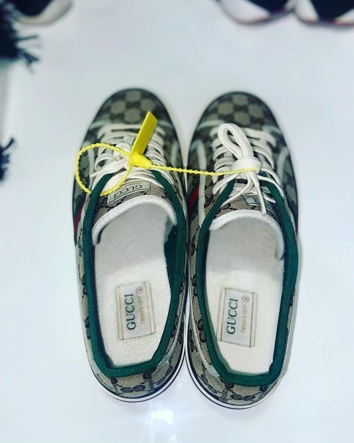 A pair of gucci shoes are sitting on a white surface.