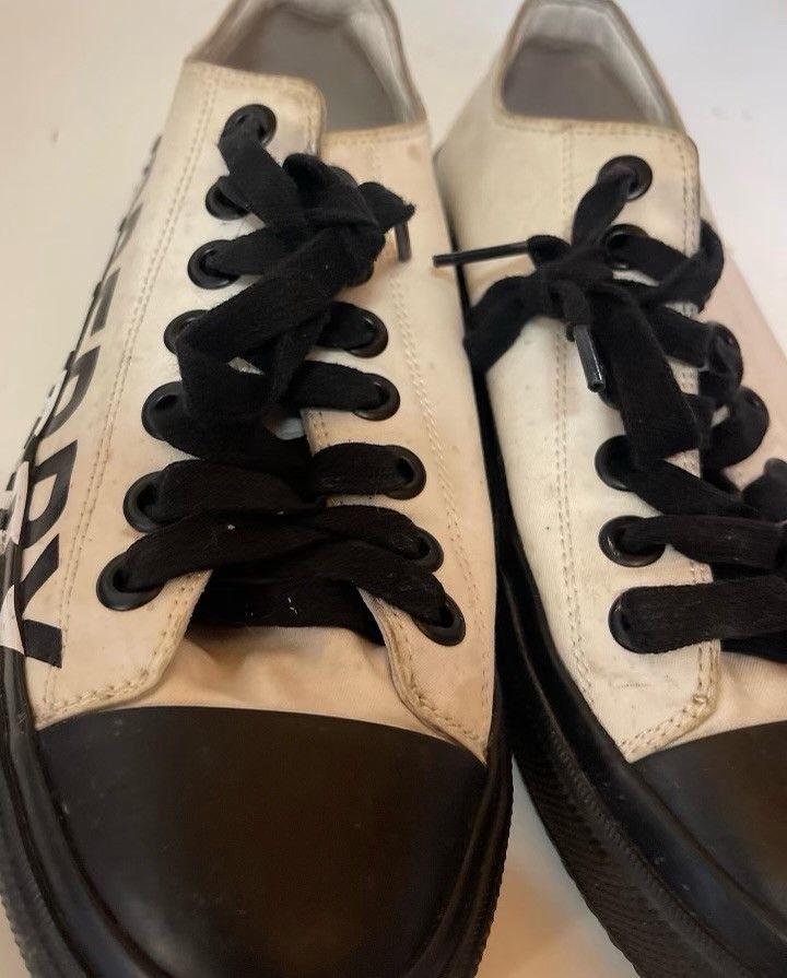 A pair of white and black sneakers with black laces