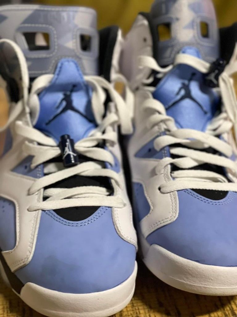 A pair of blue and white air jordans are sitting on a table.