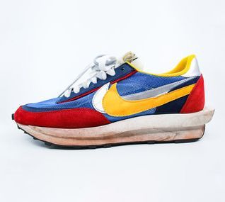 A pair of blue , red , and yellow nike sneakers on a white background.